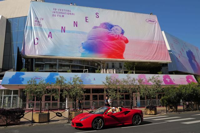 Workers install the official poster of the 78th Cannes Film Festival on the facade of the Palais des Festivals in Cannes, south-eastern France, on May 11, 2025. The 78th Cannes Film Festival will take place from May 13 to May 24, 2025. (Photo by Valery HACHE / AFP)