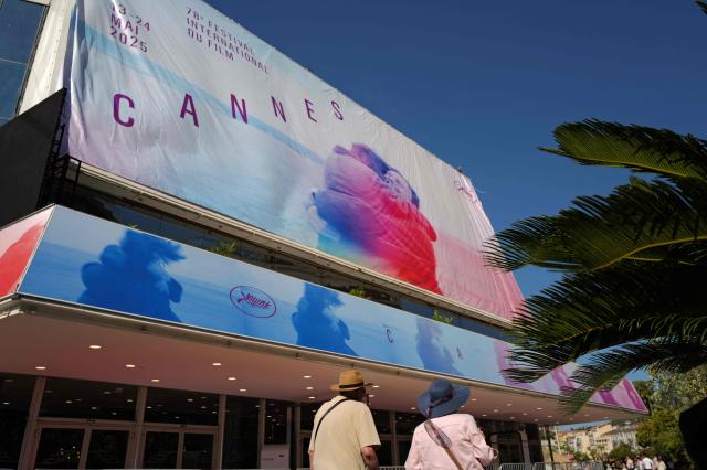 Workers install the official poster of the 78th Cannes Film Festival on the facade of the Palais des Festivals in Cannes, south-eastern France, on May 11, 2025. The 78th Cannes Film Festival will take place from May 13 to May 24, 2025. (Photo by Valery HACHE / AFP)