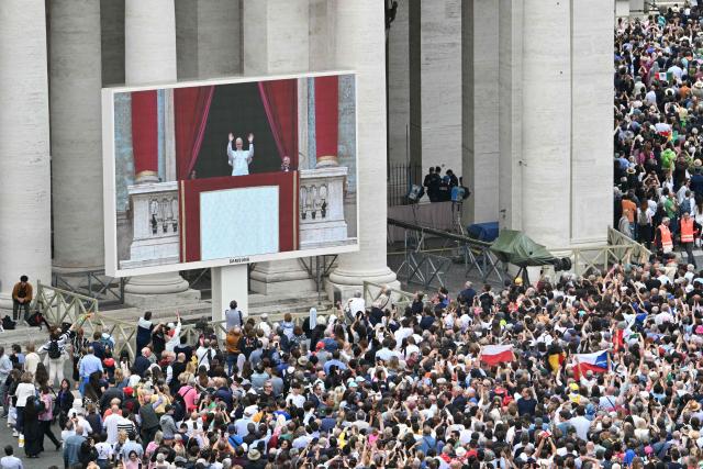 Pope Leo XIV is seen on a giant screen as he delivers the Regina Caeli prayer from the main central loggia of St Peter's basilica in The Vatican, on May 11, 2025. (Photo by Stefano Rellandini / AFP)