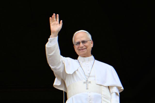 Pope Leo XIV dwaves to the crowd durng the Regina Caeli prayer from the main central loggia of St Peter's basilica in The Vatican, on May 11, 2025. (Photo by Alberto PIZZOLI / AFP)