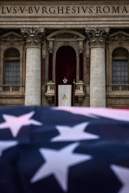 A US flag is waved as Pope Leo XIV delivers the Regina Caeli prayer from the main central loggia of St Peter's basilica in The Vatican, on May 11, 2025. (Photo by JEFF PACHOUD / AFP)
