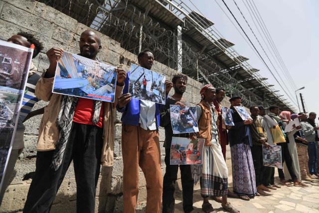 Members of Yemen's African community hold placards during a protest against last month's reported US airstrike that hit a migrant detention centre in Saada in northern Yemen, outside the United Nations office in the Houthi-controlled capital Sanaa on May 11, 2025. (Photo by Mohammed HUWAIS / AFP)