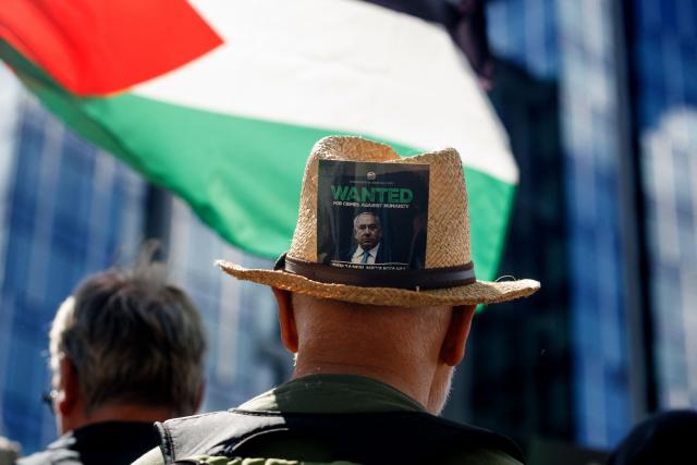 A man wears a hat with an image of the Israeli prime minister, as people take part in a protest organised by a coalition of some 60 civil society organisations, to demand a ceasefire in the Palestinian Gaza Strip, in Brussels on May 11, 2025. The war on Gaza erupted after the Palestinian Hamas militant's October 2023 attack on Israel, which resulted in the deaths of 1,218 people, mostly civilians, according to an AFP tally based on official figures. The Gaza health ministry said on may 10, 2025, that at least 2,701 people have been killed since Israel resumed its campaign in Gaza, bringing the overall death toll since the war broke out to 52,810. (Photo by HATIM KAGHAT / Belga / AFP) / Belgium OUT