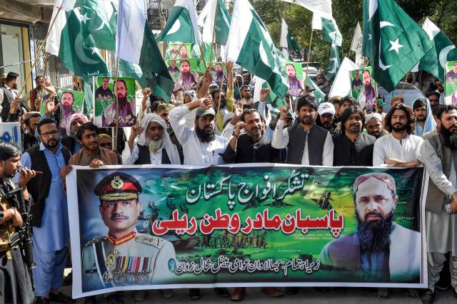People shout slogans and carry a banner with portraits of Pakistan's Chief of Army Staff General Syed Asim Munir (L) and Jhalawan Awami Panel (JAP) leader Mir Shafiq-ur Rehman Mengal during a rally after Pakistan-India ceasefire in Quetta on May 11, 2025. A ceasefire appeared to hold on May 11, between India and Pakistan, hours after the nuclear-armed rivals accused each other of violating a truce that brought them back from the brink of all-out war. (Photo by Banaras KHAN / AFP)