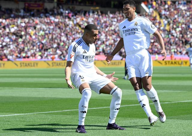 Real Madrid's French forward #09 Kylian Mbappe (L) celebrates with Real Madrid's English midfielder #05 Jude Bellingham after converting a penalty to score their first goal during the Spanish league football match between FC Barcelona and Real Madrid CF at Estadi Olimpic Lluis Companys in Barcelona, on May 11, 2025. (Photo by Josep LAGO / AFP)