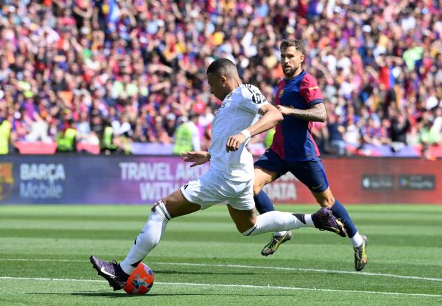 Real Madrid's French forward #09 Kylian Mbappe shoots to score their second goal during the Spanish league football match between FC Barcelona and Real Madrid CF at Estadi Olimpic Lluis Companys in Barcelona, on May 11, 2025. (Photo by Josep LAGO / AFP)