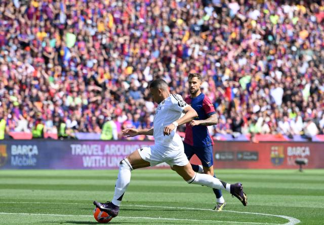 Real Madrid's French forward #09 Kylian Mbappe shoots to score their second goal during the Spanish league football match between FC Barcelona and Real Madrid CF at Estadi Olimpic Lluis Companys in Barcelona, on May 11, 2025. (Photo by Josep LAGO / AFP)