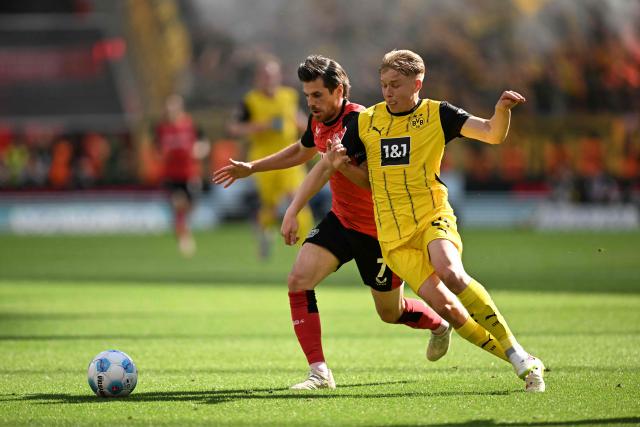 Bayer Leverkusen's German midfielder #07 Jonas Hofmann (L) and Dortmund's Swedish defender #24 Daniel Svensson vie for the ball during the German first division Bundesliga football match between Bayer 04 Leverkusen and Borussia Dortmund in Leverkusen, western Germany, on May 11, 2025. (Photo by INA FASSBENDER / AFP) / DFL REGULATIONS PROHIBIT ANY USE OF PHOTOGRAPHS AS IMAGE SEQUENCES AND/OR QUASI-VIDEO
