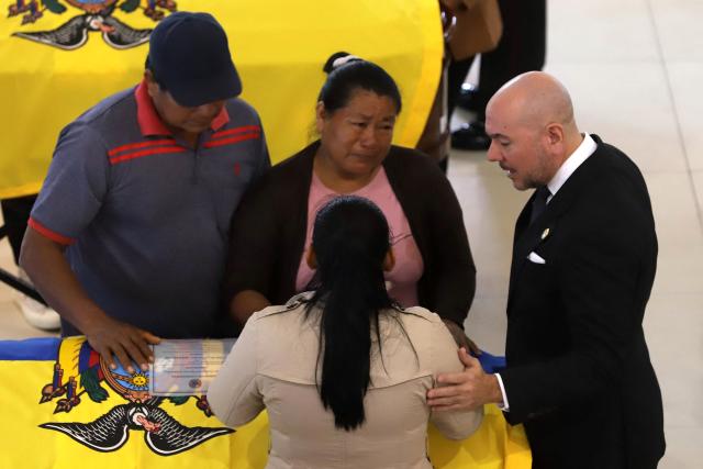 Ecuador's Defense Minister Gian Carlo Loffredo (R) comforts relatives of one of the 11 soldiers killed on May 9, during their wake at the Eloy Alfaro Military College in Quito on May 11, 2025. Ecuador declared three days of national mourning over the deaths of 11 soldiers who the army said were killed by dissident FARC guerrillas in an ambush in Alto Punino, near the Colombian border amid a spike in violence linked to the trafficking of cocaine. (Photo by ARMANDO PRADO / AFP)