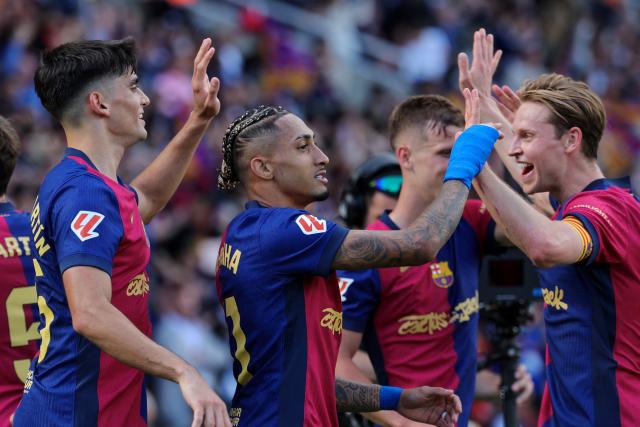 Barcelona's Brazilian forward #11 Raphinha celebrates with teammates scoring their fourth goal during the Spanish league football match between FC Barcelona and Real Madrid CF at Estadi Olimpic Lluis Companys in Barcelona, on May 11, 2025. (Photo by LLUIS GENE / AFP)