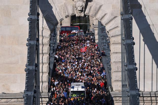 Participants in the 'March of the Living' cross the oldest Hungarian bridge the 'Lanchid' (Chain Bridge) on May 11, 2025, in Budapest. The 'March of the Living' commemorates the Holocaust victims who were deported to the concentration camps by the Nazis. (Photo by Attila KISBENEDEK / AFP)
