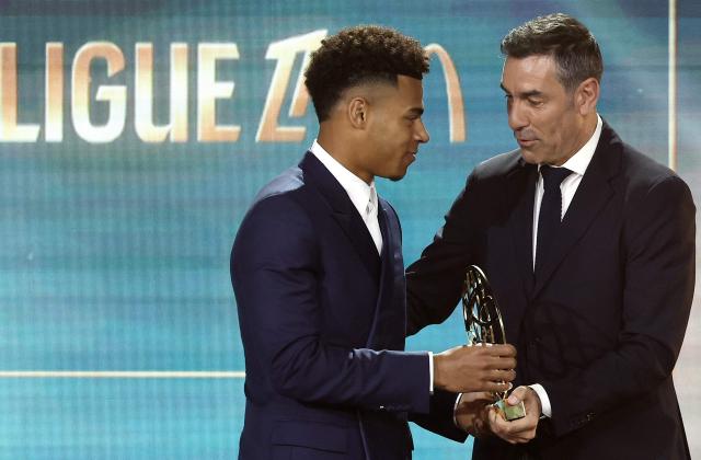 Paris Saint-Germain's French forward #14 Desire Doue (L) receives the French Ligue 1 football's best hopeful trophy from former French player Robert Pires during the 33th edition of the UNFP (French National Professional Football players Union) trophy ceremony in Paris on May 11, 2025. (Photo by FRANCK FIFE / AFP)