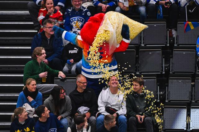 Beaty, the 2025 championship’s mascot drops popcorn on ice hockey fans during the IIHF Men's Ice Hockey World Championship round 1 group A match between Finland and France in Stockholm, on May 11, 2025. (Photo by Jonathan NACKSTRAND / AFP)