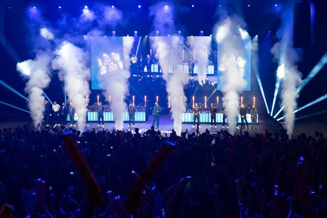 Karmine Corp's players and G2 eSports' players stand at attention as they prepare to compete against each other in the League of Legends EMEA Championship (LEC) Roadtrip - eSports competition at Les Arenes in Evry-Courcouronnes, suburb of Paris, on May 11, 2025. (Photo by LEO VIGNAL / AFP)