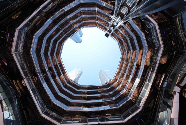 People walk around on the Vessel at Hudson Yards in New York city on May 11, 2025. The Vessel reopened in October 2024 after being closed for three years, now with netting aimed at decreasing the risk of suicides like the ones that forced its closure. (Photo by TIMOTHY A. CLARY / AFP)