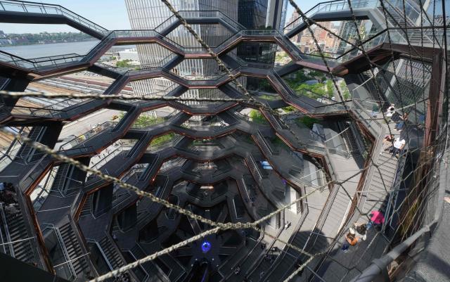 People walk around on the Vessel at Hudson Yards in New York city on May 11, 2025. The Vessel reopened in October 2024 after being closed for three years, now with netting aimed at decreasing the risk of suicides like the ones that forced its closure. (Photo by TIMOTHY A. CLARY / AFP)