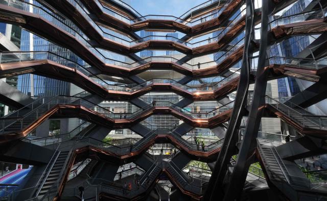 People walk around on the Vessel at Hudson Yards in New York city on May 11, 2025. The Vessel reopened in October 2024 after being closed for three years, now with netting aimed at decreasing the risk of suicides like the ones that forced its closure. (Photo by TIMOTHY A. CLARY / AFP)