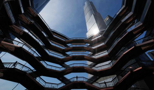 People walk around on the Vessel at Hudson Yards in New York city on May 11, 2025. The Vessel reopened in October 2024 after being closed for three years, now with netting aimed at decreasing the risk of suicides like the ones that forced its closure. (Photo by TIMOTHY A. CLARY / AFP)