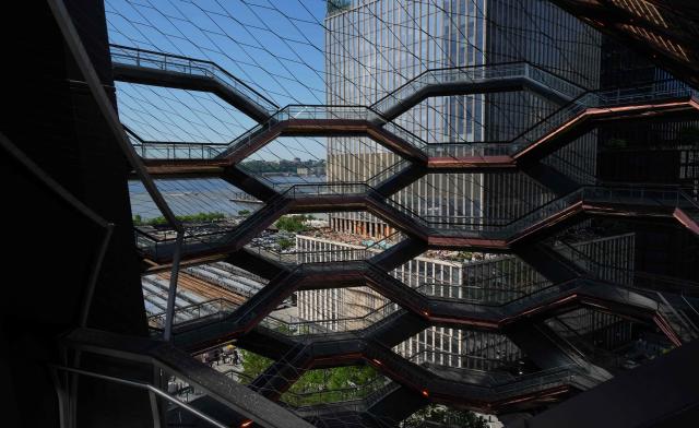 People walk around on the Vessel at Hudson Yards in New York city on May 11, 2025. The Vessel reopened in October 2024 after being closed for three years, now with netting aimed at decreasing the risk of suicides like the ones that forced its closure. (Photo by TIMOTHY A. CLARY / AFP)