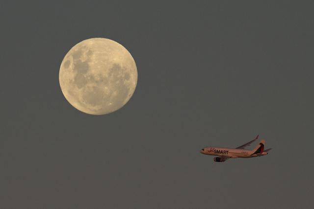 A JetSmart Airlines airplane passes by the almost full moon after taking off from Jorge Newbery Airport in Buenos Aires on May 11, 2025. (Photo by JUAN MABROMATA / AFP)