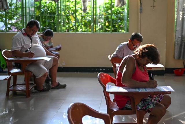 People vote at a polling station during mid-term elections in Manila on May 12, 2025. Millions of Filipinos headed to the polls May 12 in a mid-term election widely seen as a referendum on the explosive feud between President Ferdinand Marcos and impeached Vice President Sara Duterte. (Photo by Jam STA ROSA / AFP)