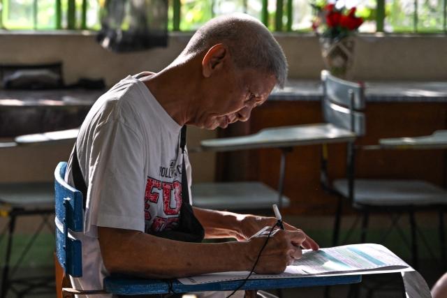 A man votes at a polling station during mid-term elections in Manila on May 12, 2025. Millions of Filipinos headed to the polls May 12 in a mid-term election widely seen as a referendum on the explosive feud between President Ferdinand Marcos and impeached Vice President Sara Duterte. (Photo by Jam STA ROSA / AFP)