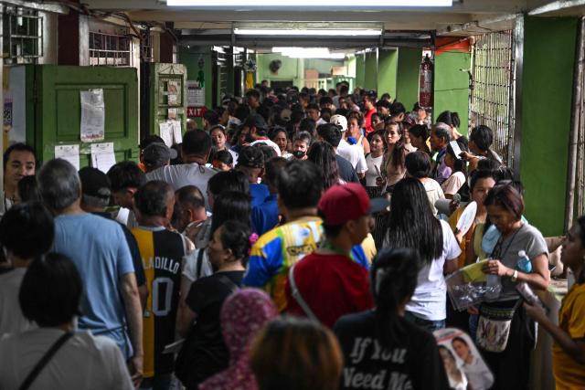 People wait in line to vote at a polling station during mid-term elections in Manila on May 12, 2025. Millions of Filipinos headed to the polls May 12 in a mid-term election widely seen as a referendum on the explosive feud between President Ferdinand Marcos and impeached Vice President Sara Duterte. (Photo by Jam STA ROSA / AFP)