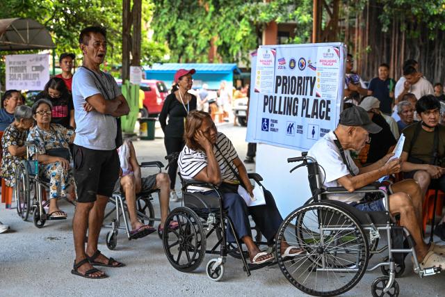 Wheelchair-bound voters wait in line at a polling station's priority section during mid-term elections in Manila on May 12, 2025. Millions of Filipinos headed to the polls May 12 in a mid-term election widely seen as a referendum on the explosive feud between President Ferdinand Marcos and impeached Vice President Sara Duterte. (Photo by Jam STA ROSA / AFP)