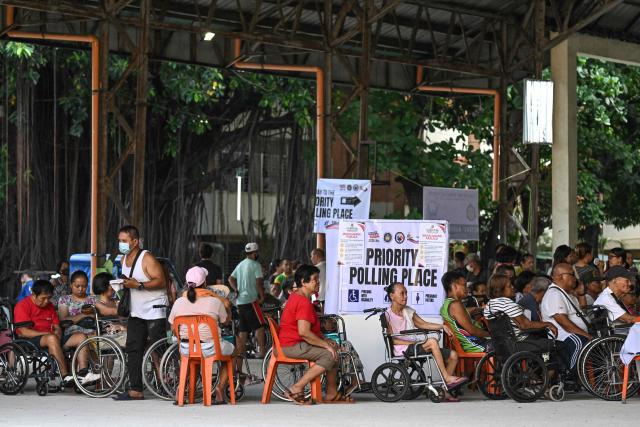 Wheelchair-bound voters wait in line at a polling station's priority section during mid-term elections in Manila on May 12, 2025. Millions of Filipinos headed to the polls May 12 in a mid-term election widely seen as a referendum on the explosive feud between President Ferdinand Marcos and impeached Vice President Sara Duterte. (Photo by Jam STA ROSA / AFP)