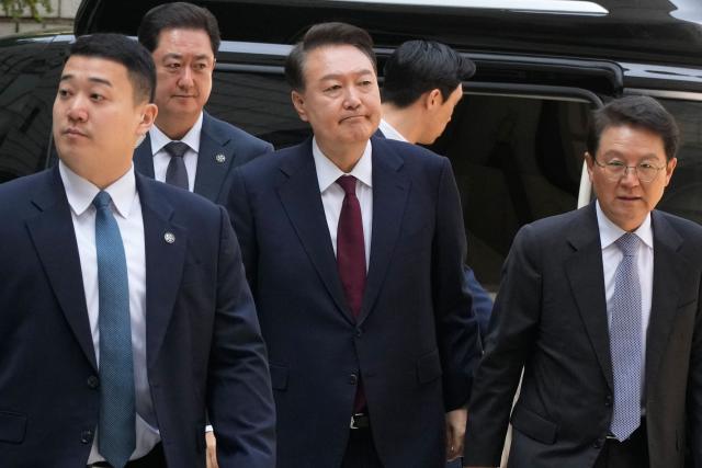South Korea's ousted President Yoon Suk Yeol (C), who is facing charges of orchestrating a rebellion when he declared martial law on December 3, 2024, arrives to attend his trial at the Seoul Central District Court in Seoul on May 12, 2025. South Korea's former president Yoon Suk Yeol appeared in court May 12 for the third hearing of his criminal trial to defend himself against insurrection charges over his short-lived declaration of martial law. (Photo by Ahn Young-joon / POOL / AFP)
