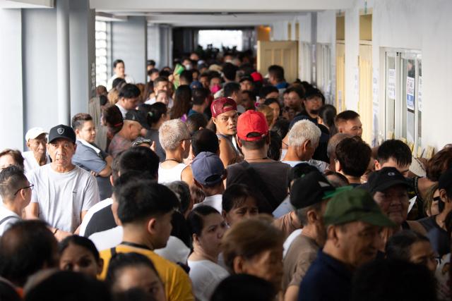 A crowd gathers to vote in the mid-term election at a polling station in Manila on May 12, 2025. Millions of Filipinos headed to the polls May 12 in a mid-term election widely seen as a referendum on the explosive feud between President Ferdinand Marcos and impeached Vice President Sara Duterte. (Photo by Ted ALJIBE / AFP)