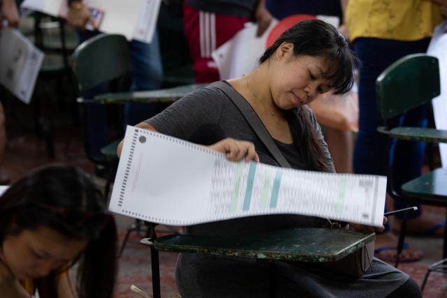 A woman votes in the mid-term election at a polling station in Manila on May 12, 2025. Millions of Filipinos headed to the polls May 12 in a mid-term election widely seen as a referendum on the explosive feud between President Ferdinand Marcos and impeached Vice President Sara Duterte. (Photo by Ted ALJIBE / AFP)