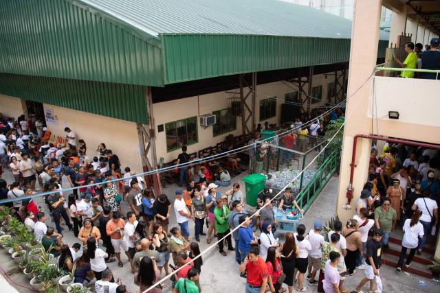 People gather to vote in the mid-term election at a polling station in Manila on May 12, 2025. Millions of Filipinos headed to the polls May 12 in a mid-term election widely seen as a referendum on the explosive feud between President Ferdinand Marcos and impeached Vice President Sara Duterte. (Photo by Ted ALJIBE / AFP)