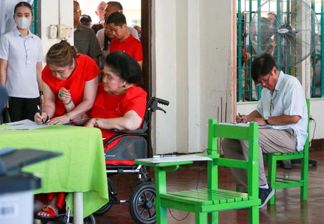 Philippine President Ferdinand Marcos (R) and his mother, former first lady Imelda Marcos (3rd L, in wheelchair) vote in the mid-term election at a polling station in Batac town, Ilocos Norte province on May 12, 2025. Millions of Filipinos headed to the polls May 12 in a mid-term election widely seen as a referendum on the explosive feud between President Ferdinand Marcos and impeached Vice President Sara Duterte. (Photo by AFP)