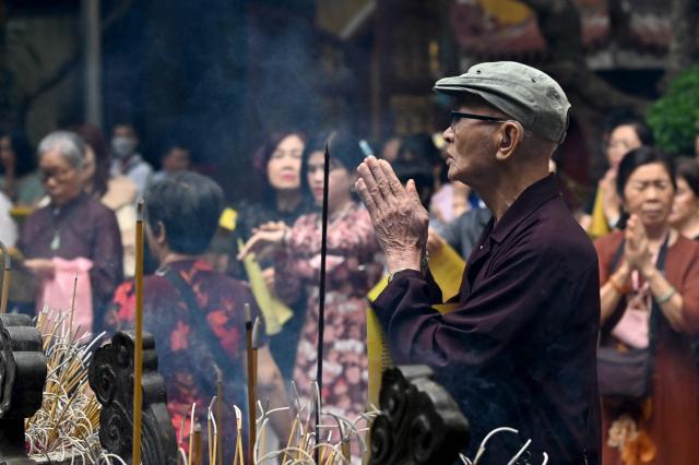 A man prays at the Quan Su Pagoda in Hanoi on May 12, 2025, as Buddhists celebrated Vesak Day, or Buddha Day, which marks the Buddha's birth. (Photo by Nhac NGUYEN / AFP)