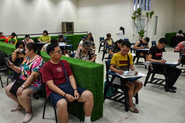 People vote in the mid-term election at a polling station set up in a mall in Manila on May 12, 2025. Millions of Filipinos headed to the polls May 12 in a mid-term election widely seen as a referendum on the explosive feud between President Ferdinand Marcos and impeached Vice President Sara Duterte. (Photo by Jam STA ROSA / AFP)