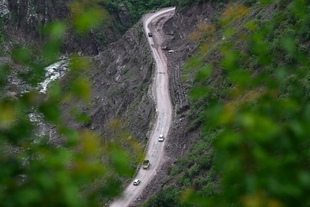 Vehicles make their way along a road in Uri, about 100kms from Srinagar on May 11, 2025. Indian and Pakistani military chiefs were set to confer on May 12 as a ceasefire that brought the nuclear-armed rivals back from the brink of all-out war held. US President Donald Trump announced the truce late on May 10 after four days of missile, drone and artillery attacks which killed at least 60 people and sent thousands fleeing on both sides. (Photo by Tauseef MUSTAFA / AFP)