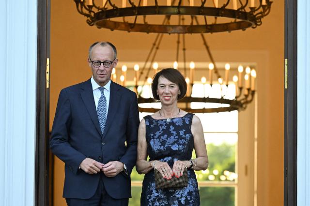 German Chancellor Friedrich Merz (L) and his wife Charlotte Merz pose upon arrival for a gala dinner with the Israeli President on May 12, 2025 at the Bellevue Palace in Berlin. Israeli President Isaac Herzog is visiting Germany to mark the 60th anniversary of diplomatic relations between the two countries. (Photo by RALF HIRSCHBERGER / AFP)