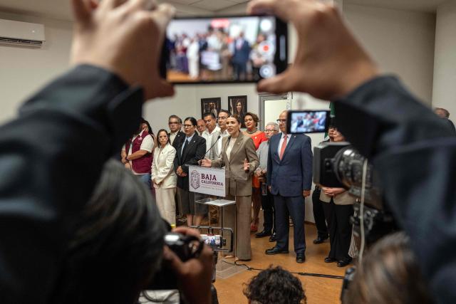 Baja California Governor Marina del Pilar Avila (C), accompanied by members of her cabinet, delivers a statement on the revocation of her visa by US authorities in Tijuana, Baja California State, Mexico, on May 12, 2025. (Photo by Guillermo Arias / AFP)