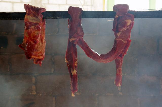 Smoked beef is prepared for preservation due to a lack of refrigerators in the municipality of Oxchuc, Chiapas State, Mexico, on May 7, 2025. Peering through a microscope, food scientist Raquel Gomez studies microorganisms that add nutrients and help to preserve tortillas for longer without refrigerators that are a luxury in impoverished Mexican communities. (Photo by Raul VERA / AFP)