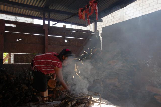 A Tseltal Indigenous woman prepares smoked beef for preservation due to a lack of refrigerators in the municipality of Oxchuc, Chiapas State, Mexico, on May 7, 2025. Peering through a microscope, food scientist Raquel Gomez studies microorganisms that add nutrients and help to preserve tortillas for longer without refrigerators that are a luxury in impoverished Mexican communities. (Photo by Raul VERA / AFP)