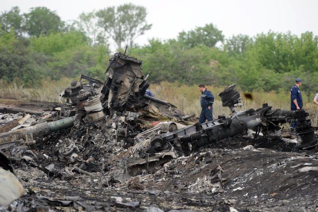 (FILES) Rescuers stand on July 18, 2014 on the site of the crash of a Malaysian airliner carrying 298 people from Amsterdam to Kuala Lumpur, near the town of Shaktarsk, in rebel-held east Ukraine. The United Nations aviation agency said on May 12, 2025 that Russia was responsible for the downing of a Malaysian Airways jetliner over Ukraine in 2014, with the death of 298 people. The International Civil Aviation Organization, based in Montreal, said claims brought by Australia and the Netherlands over the shooting down of Flight MH17 on July 17, 2014 were "well founded in fact and in law." (Photo by DOMINIQUE FAGET / AFP)