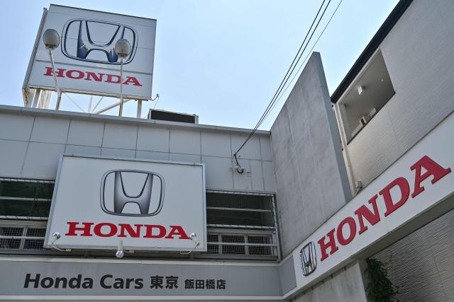 This photo shows signage at a car dealership for Japanese automaker Honda Motor along a street in central Tokyo on May 13, 2025, ahead of the company's annual results announcement later in the day. (Photo by Richard A. Brooks / AFP)