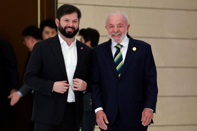 Brazil President Luiz Inacio Lula da Silva (R) and Chile President Gabriel Boric (L) chat ahead of a group photo session before the opening ceremony of the Fourth Ministerial Meeting of the Forum of China and Community of Latin American and Caribbean States (CELAC) in Beijing on May 13, 2025. (Photo by FLORENCE LO / POOL / AFP)