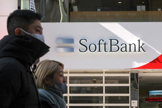 (FILES) This file photo taken on February 8, 2022 shows pedestrians walking past a SoftBank mobile shop in Tokyo. Japanese tech investment giant SoftBank Group were expected on May 13, 2025 to announce their 2024 fiscal year annual results later in the day. (Photo by Kazuhiro NOGI / AFP)