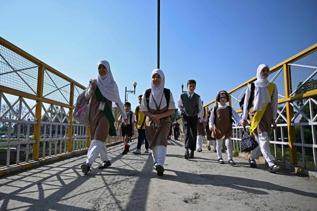 Students walk to attend classes as their school reopened after a ceasefire between Pakistan and India, in Srinagar on May 13, 2025. Indian Prime Minister Narendra Modi vowed on May 12 to respond strongly to any future "terrorist attack", and warned that New Delhi would not tolerate "nuclear blackmail" in the event of further conflict with Pakistan. (Photo by SAJJAD HUSSAIN / AFP)