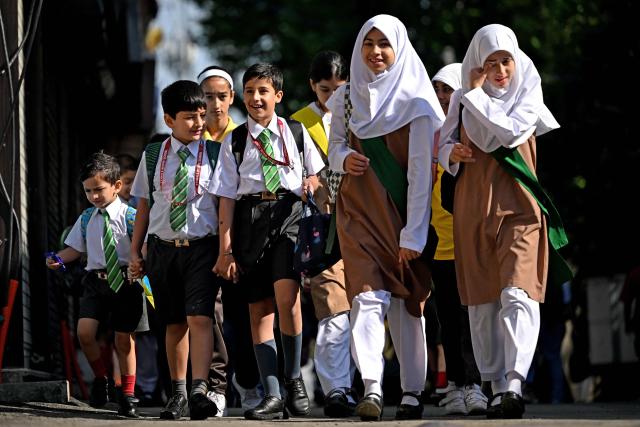 Students walk to attend classes as their school reopened after a ceasefire between Pakistan and India, in Srinagar on May 13, 2025. Indian Prime Minister Narendra Modi vowed on May 12 to respond strongly to any future "terrorist attack", and warned that New Delhi would not tolerate "nuclear blackmail" in the event of further conflict with Pakistan. (Photo by SAJJAD HUSSAIN / AFP)