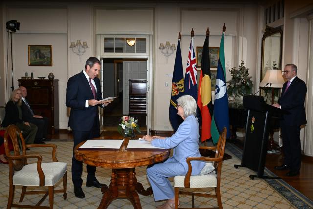 Australian Treasurer Jim Chalmers (L) is sworn in by Australian Governor-General Sam Mostyn during a swearing-in ceremony at Government House in Canberra on May 13, 2025. (Photo by Saeed Khan / AFP)