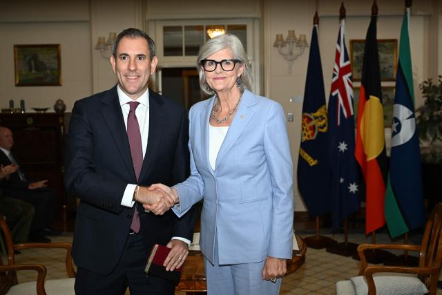 Australian Treasurer Jim Chalmers (L) shakes hands with Australian Governor-General Sam Mostyn during a swearing-in ceremony at Government House in Canberra on May 13, 2025. (Photo by Saeed Khan / AFP)