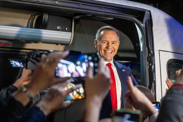Karol Nawrocki, candidate for the 2025 Polish presidential election supported by Poland's right-wing Law and Justice (PiS) party, greets supporters from his campaign van after a presidential debate at the Polish National Television headquarters in Warsaw on May 12, 2025. Poland will hold presidential election on May 18, 2025. (Photo by Wojtek RADWANSKI / AFP)